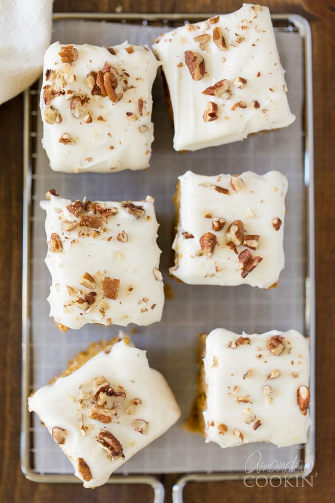 6 squares of frosted pumpkin cake on parchment