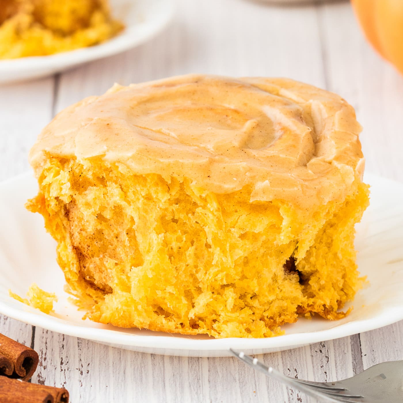 Close up photo of a Pumpkin Cinnamon Roll on a plate