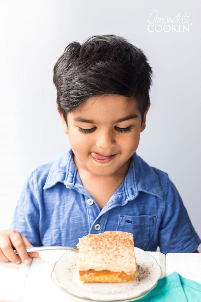 little boy licking lips waiting to eat cake