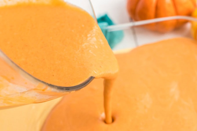 pouring pumpkin cake batter into pan