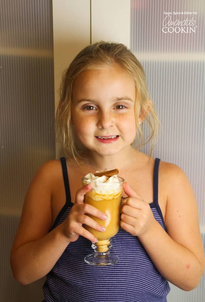Girl holding pumpkin spice hot chocolate in a mug