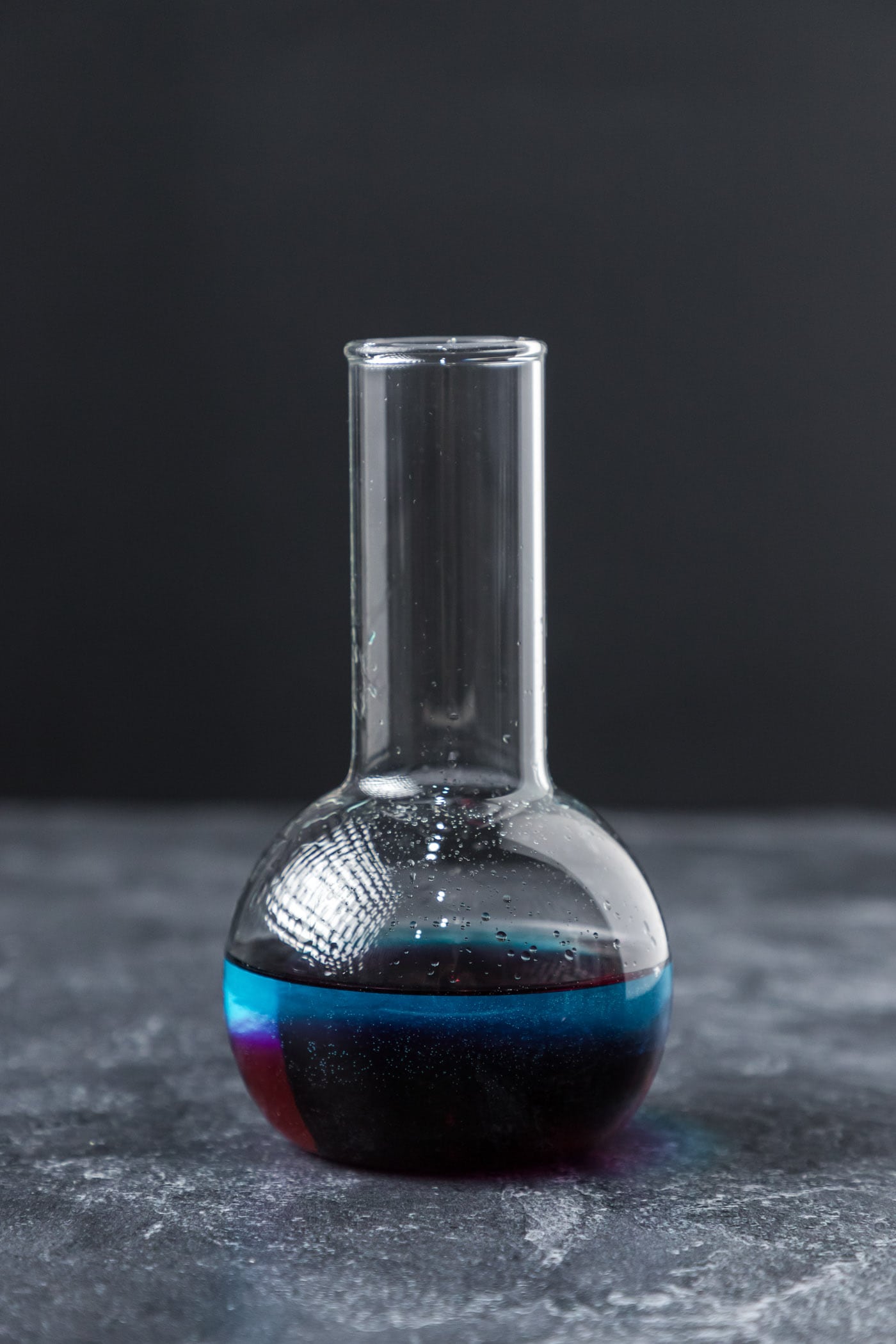 purple people eater cocktail in a beaker glass