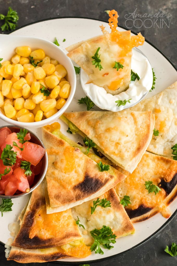 quesados mexican appetizer slices on plate with condiments