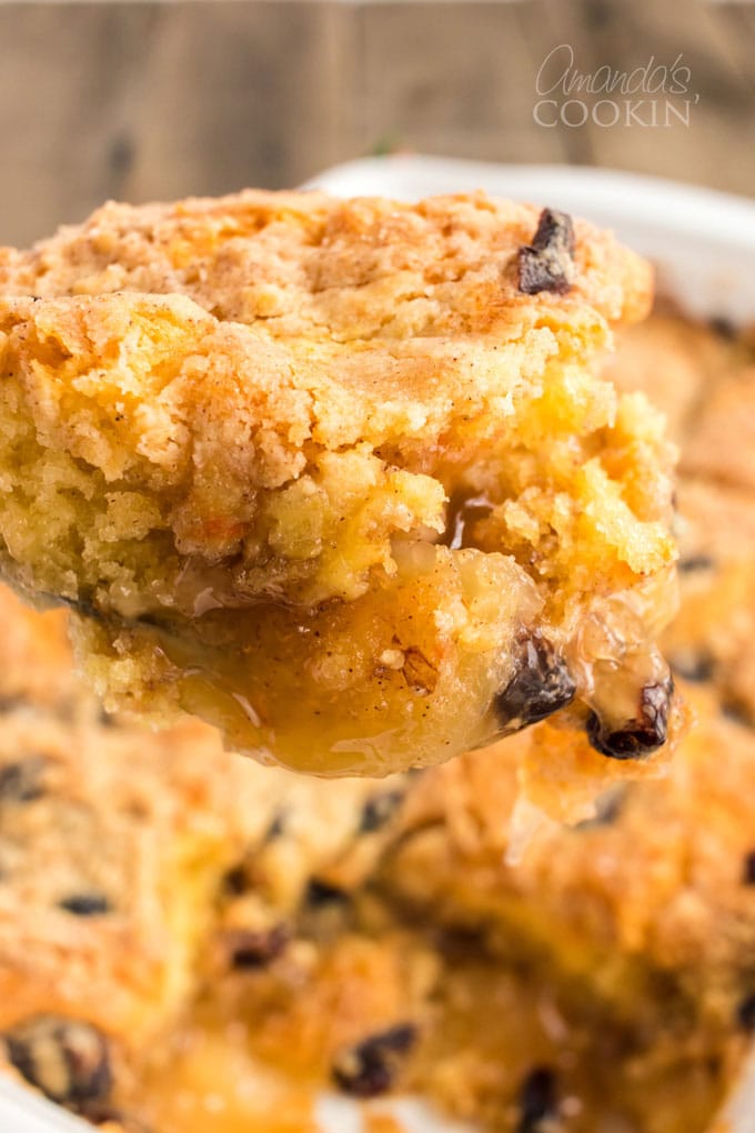 scooping apple cranberry cobbler out of pan