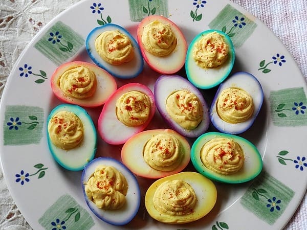 An overhead photo of rainbow deviled eggs on a platter.