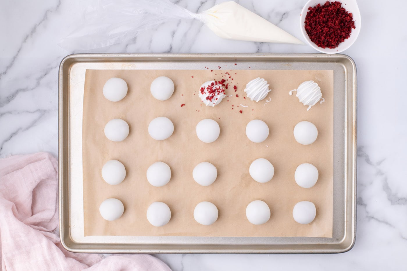 sprinkling cake crumbles on top of red velvet cake balls