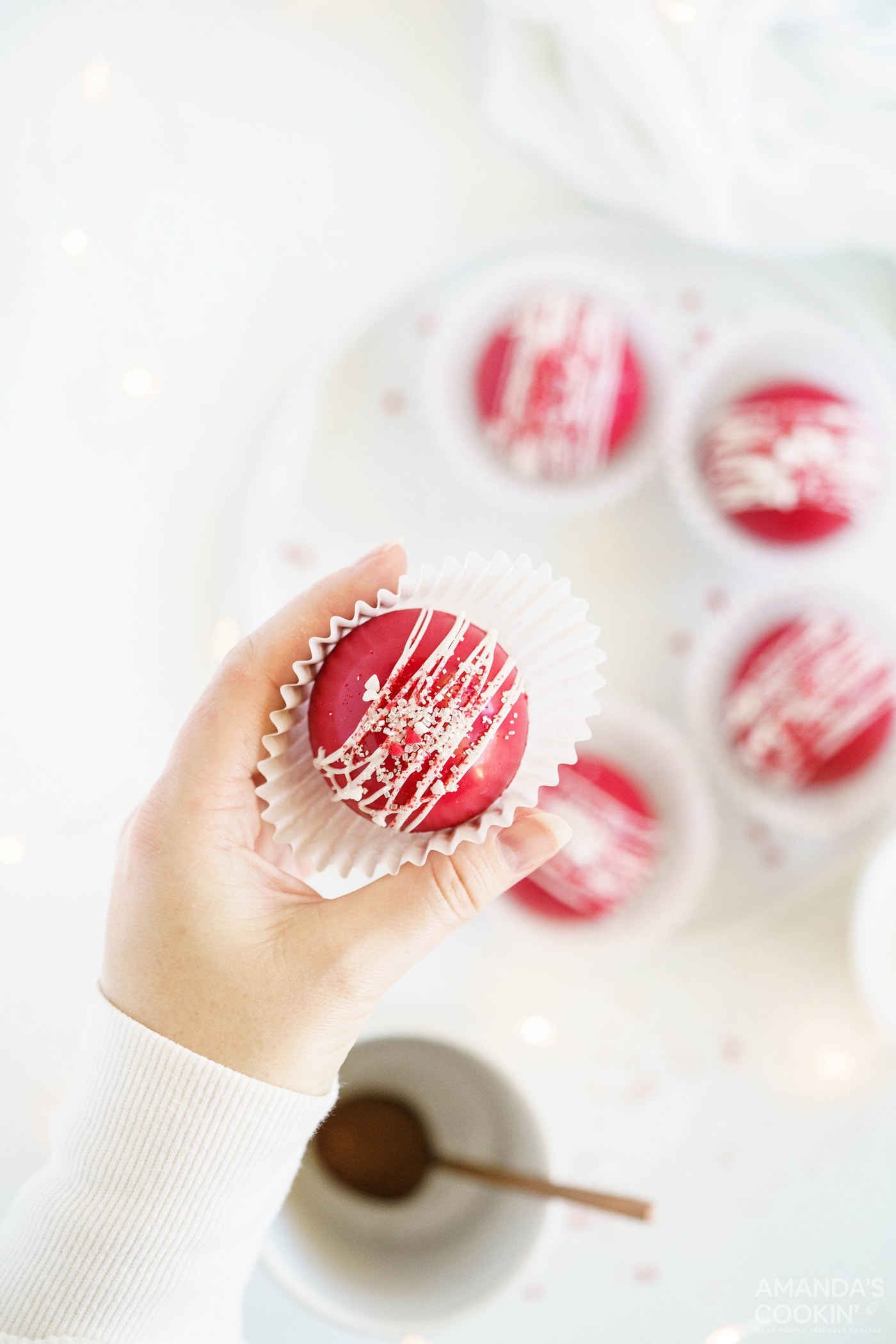 woman holding paper lined red velvet cocoa bomb