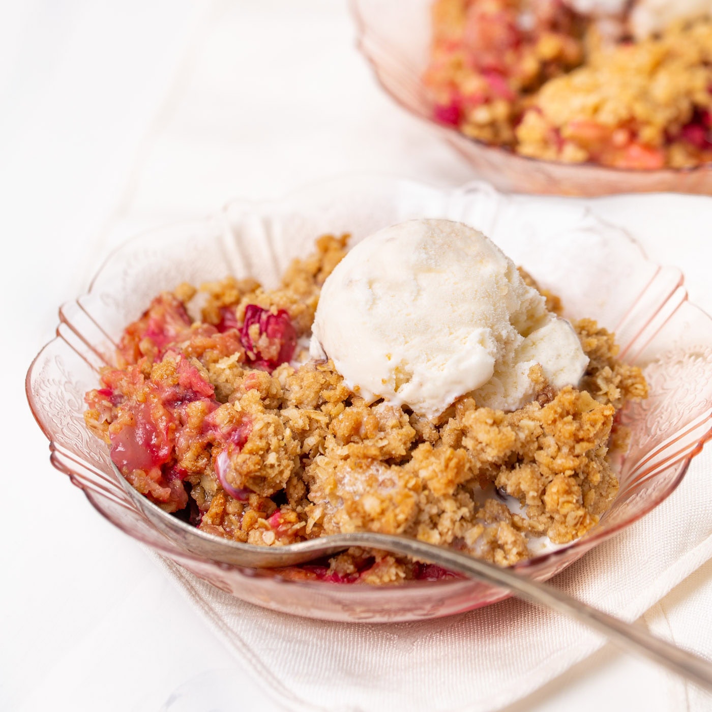 Rhubarb Crisp in a bowl topped with ice cream