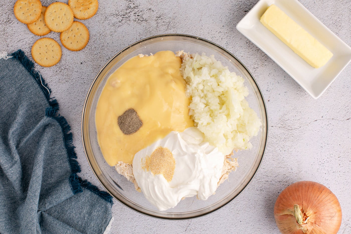 cream of chicken soup, sour cream, onion, chicken, and seasonings in a bowl