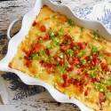 An overhead photo of a pan of bacon topped three cheese potatoes.