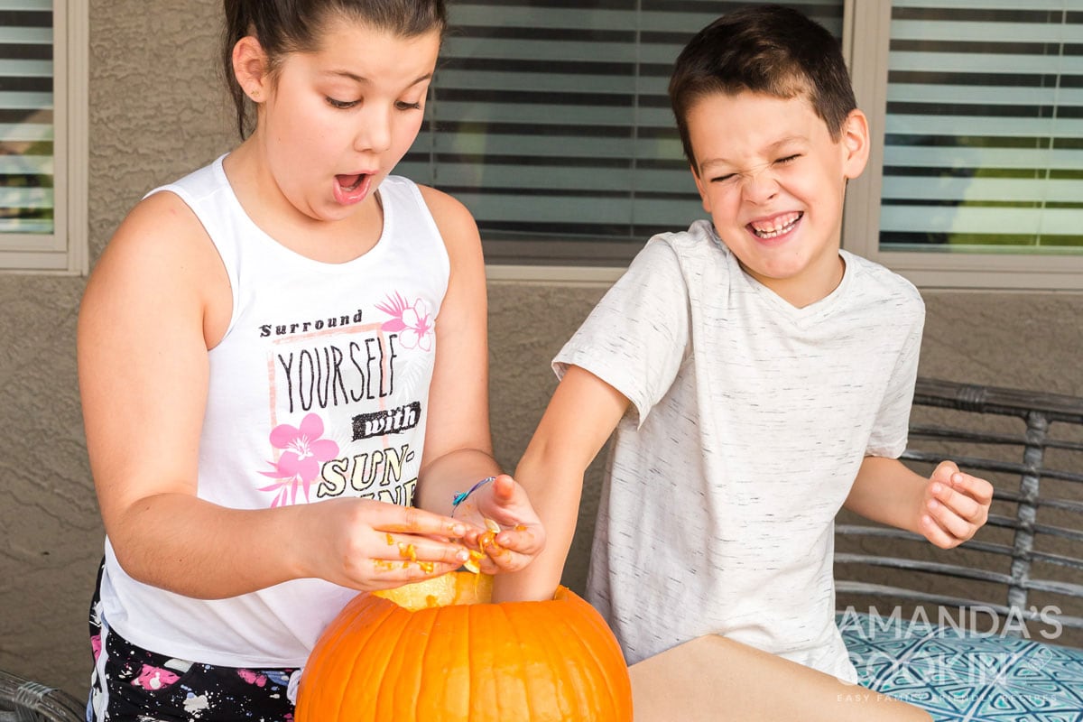 kids cleaning out a pumpkin