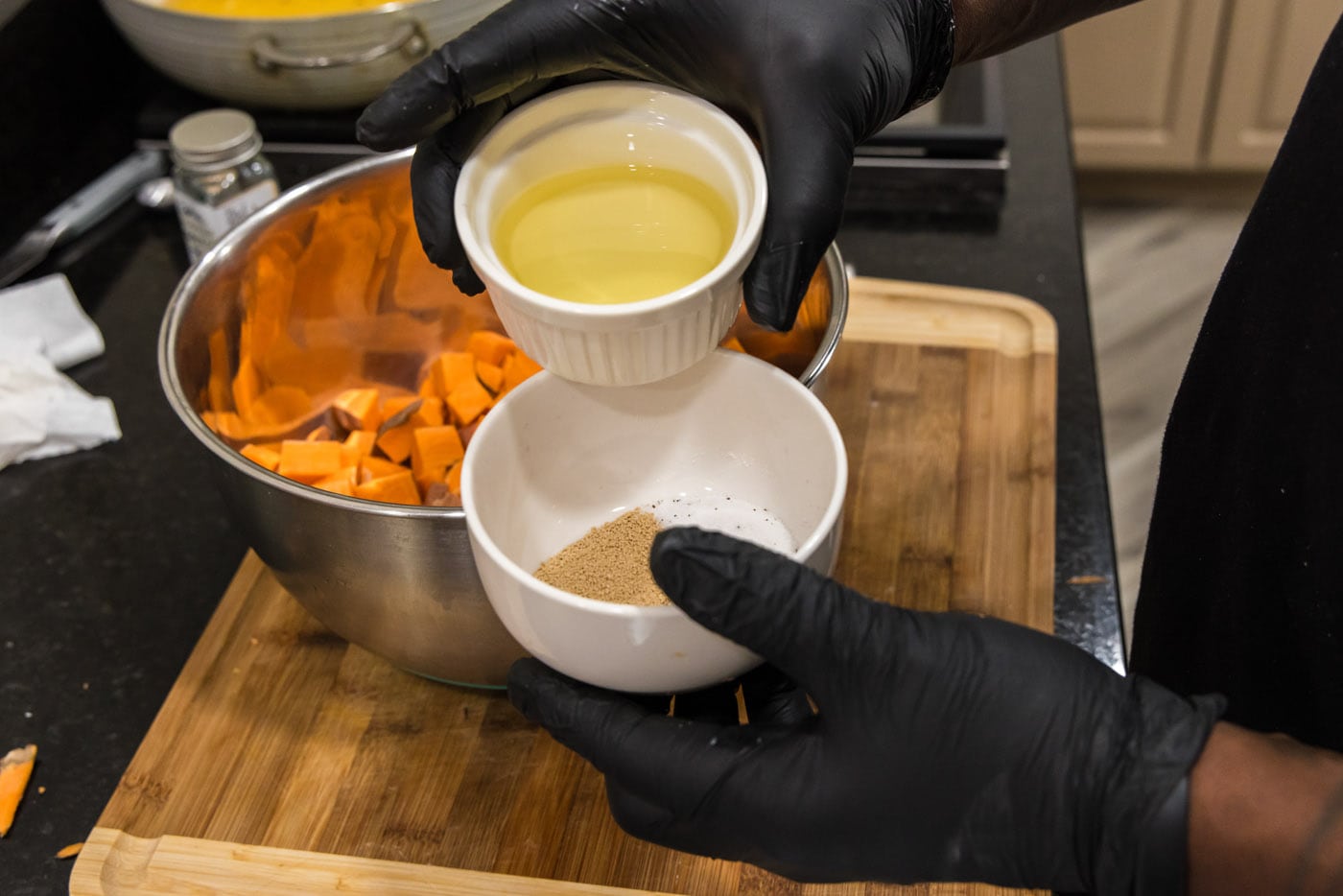 adding olive oil to seasonings in a bowl