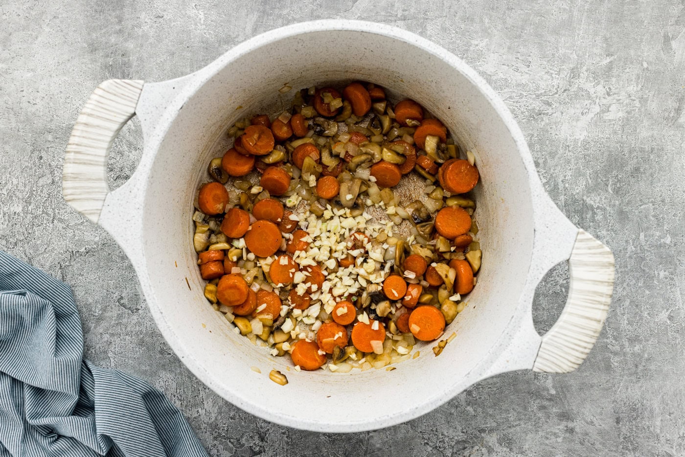 onion, mushrooms, garlic, and carrots in a Dutch oven with butter