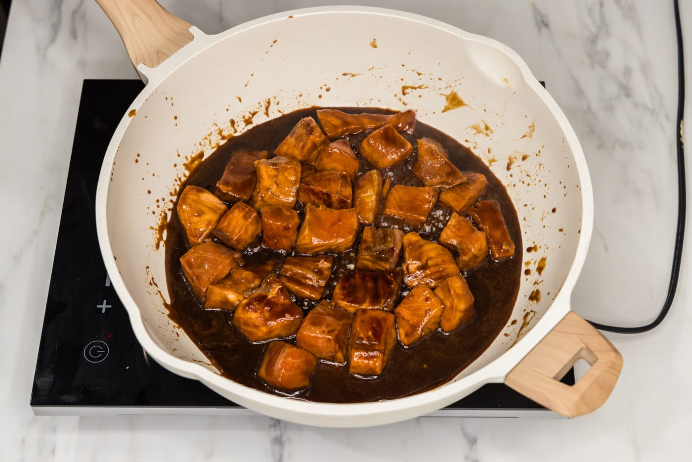 cooking salmon bites in marinde in a skillet