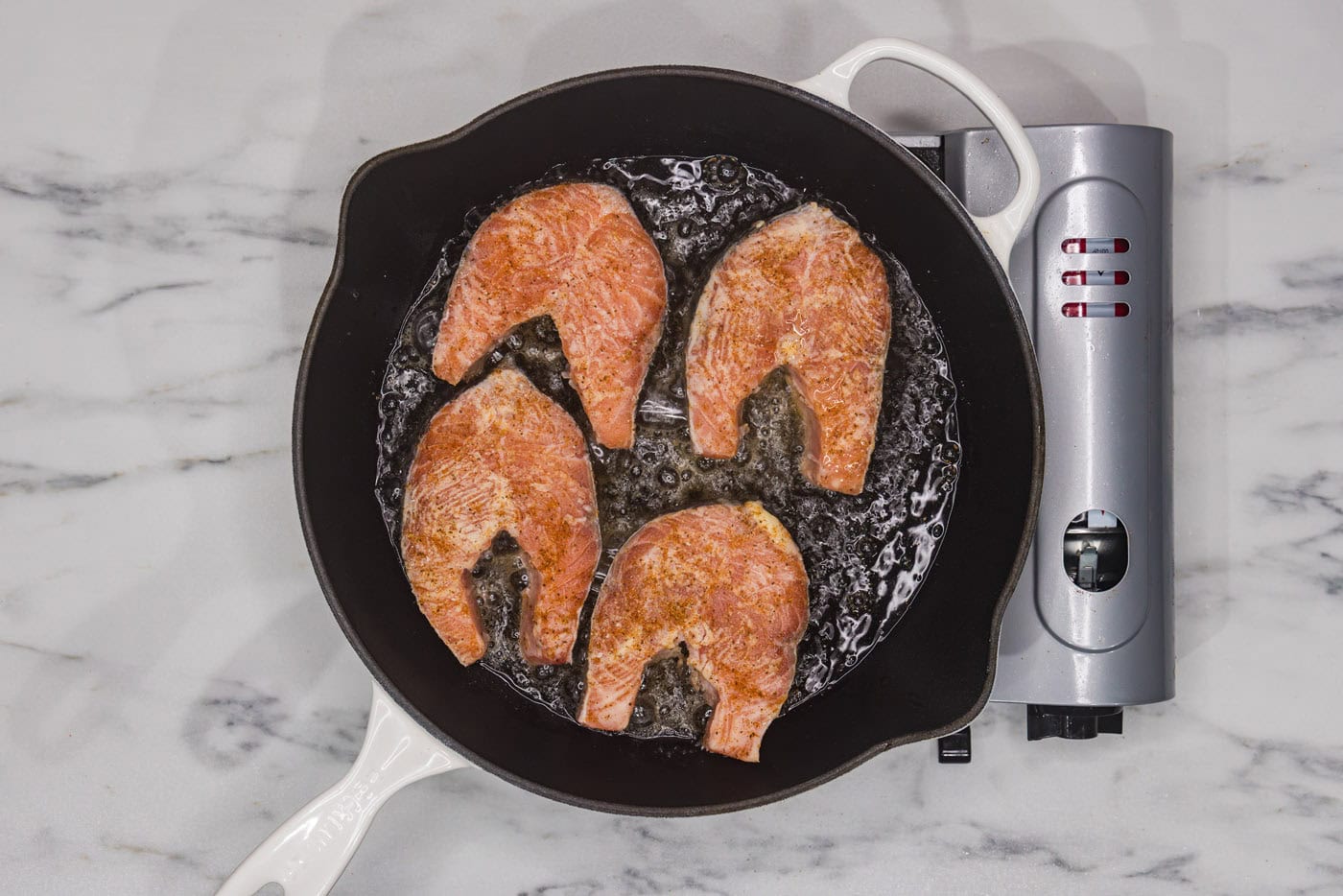 salmon steaks cooking in a skillet