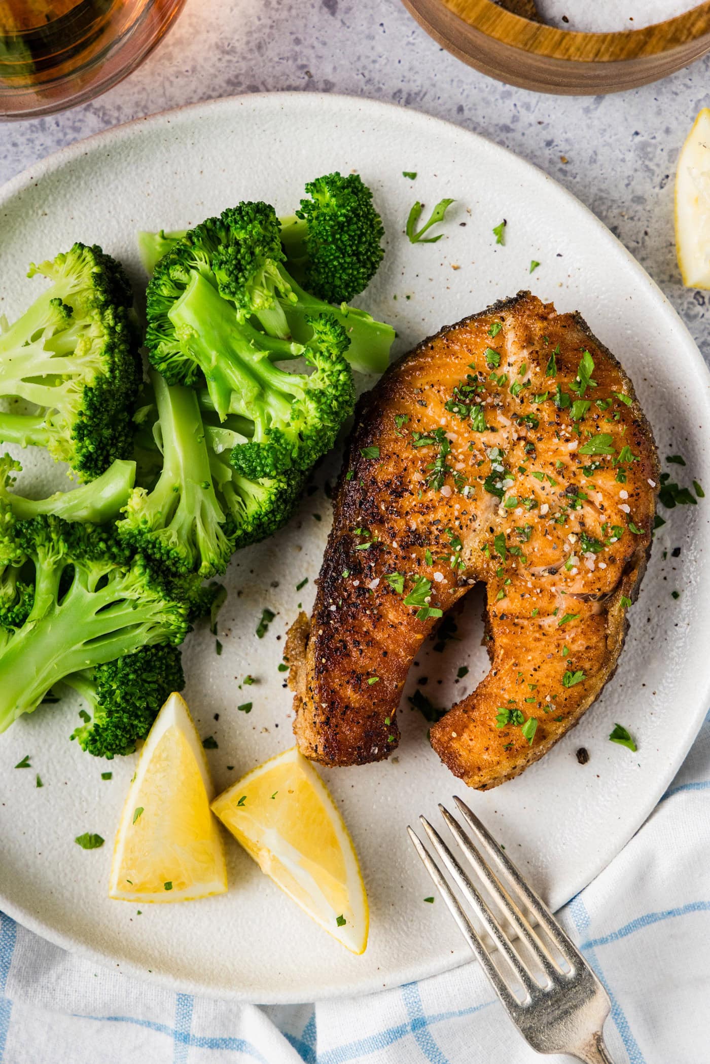 Salmon Steak on a plate with broccoli and lemons on the side