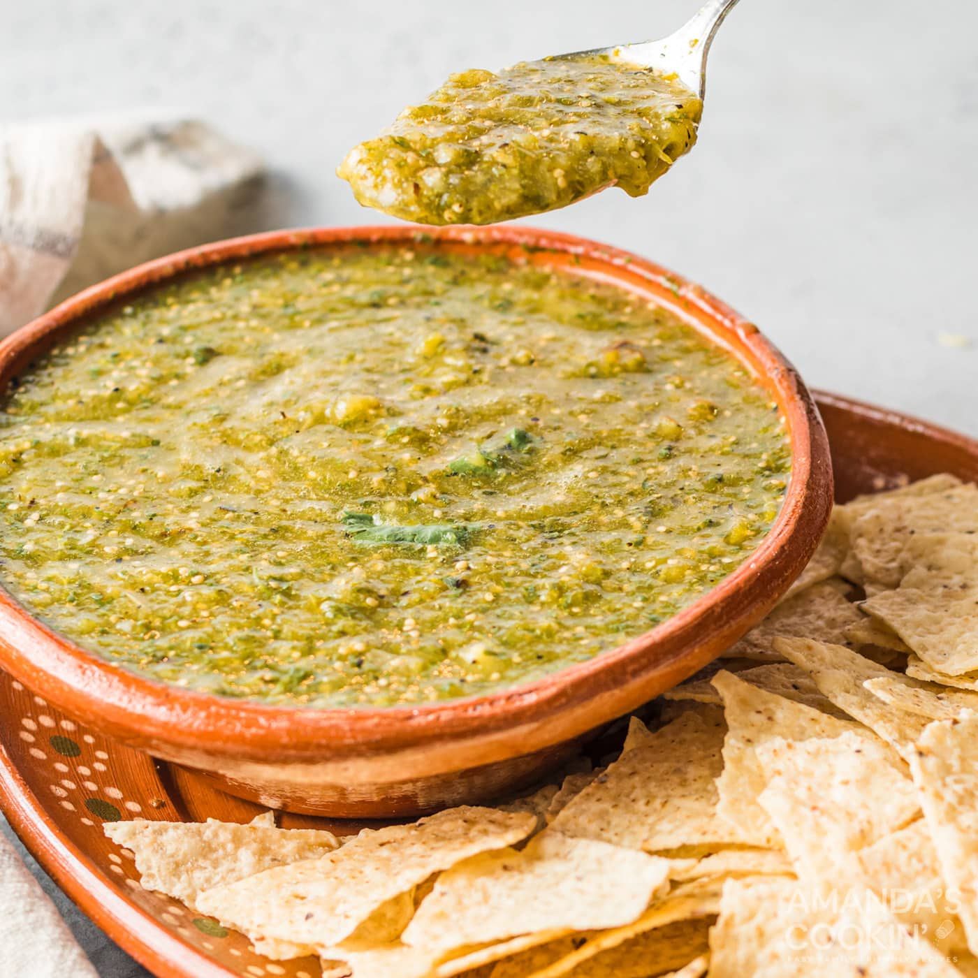 spoon lifting some salsa verde from bowl