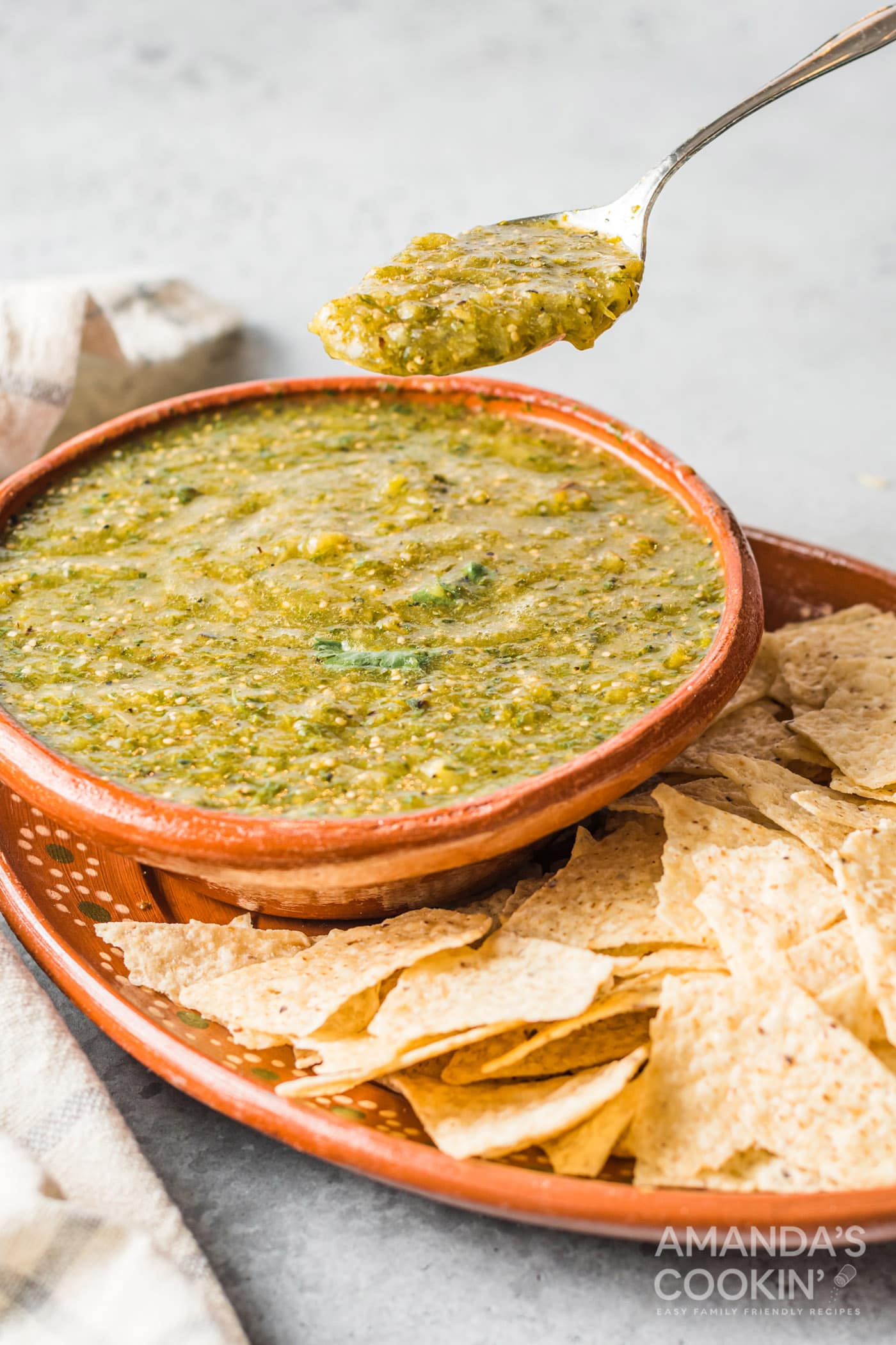 spoon lifting some salsa verde from bowl
