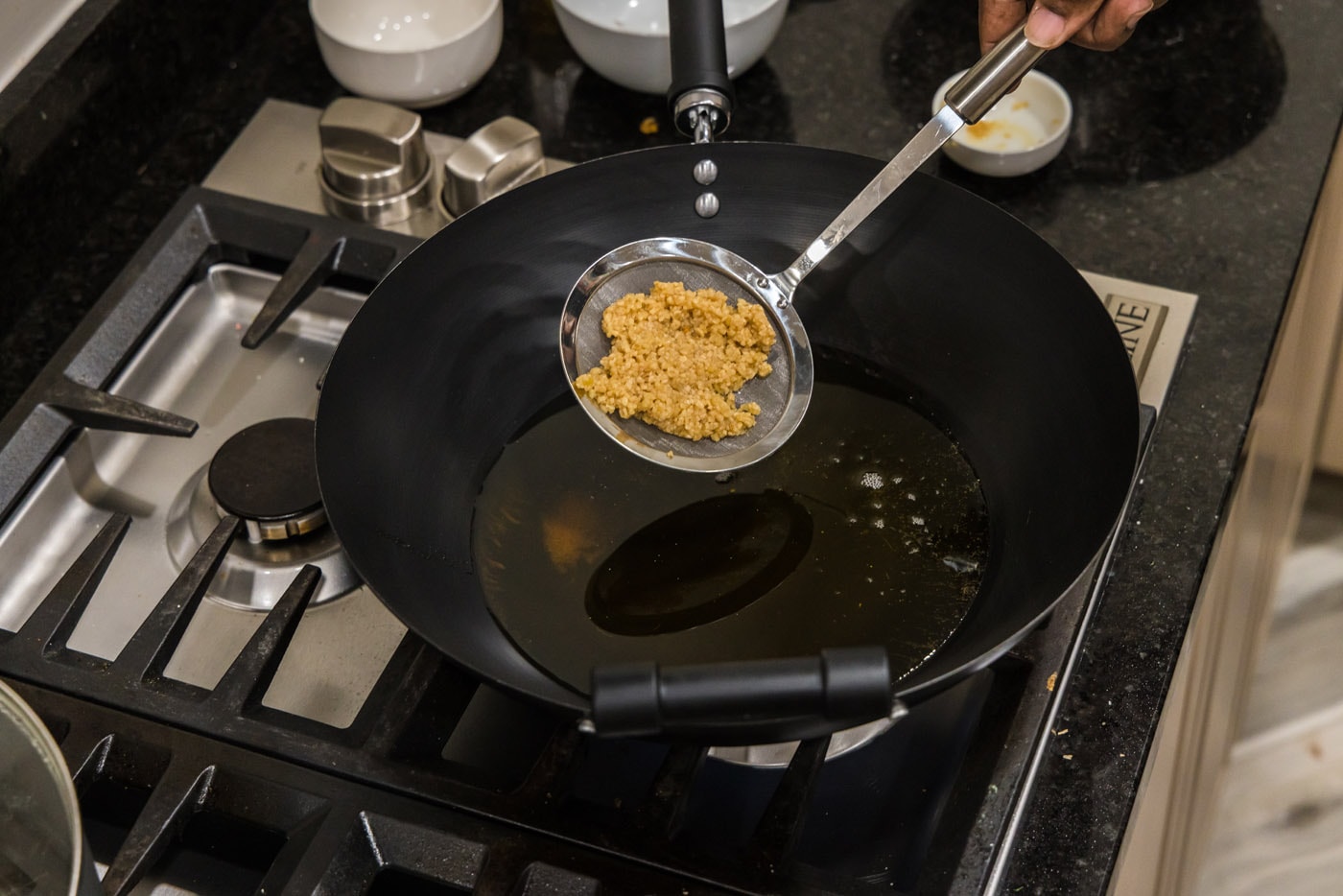 adding minced garlic to hot oil