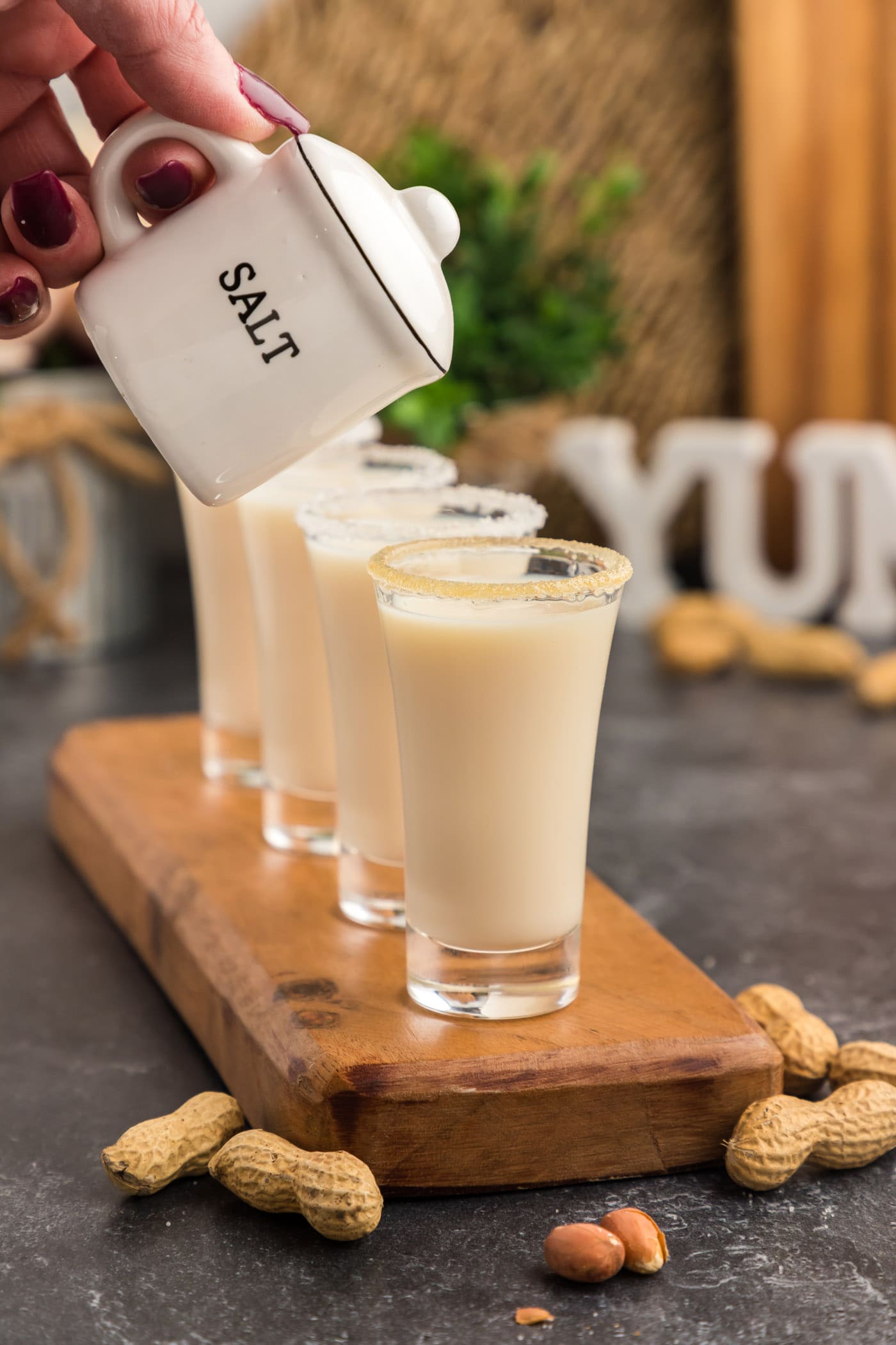 Salt shaker held above a row of Salted Nut Roll Shots