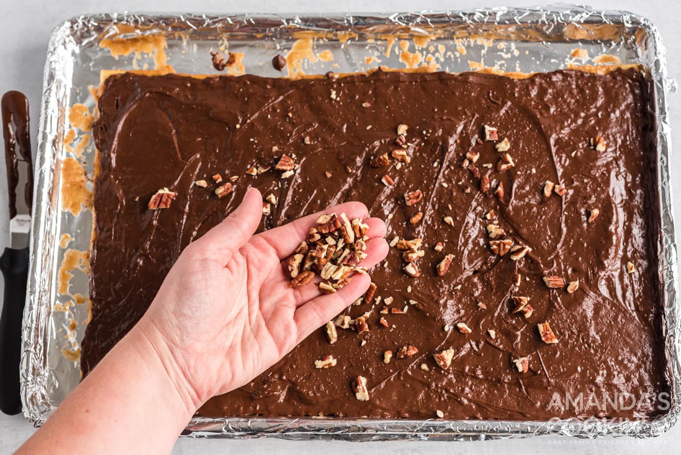 chopped nuts sprinkled on top of saltine toffee