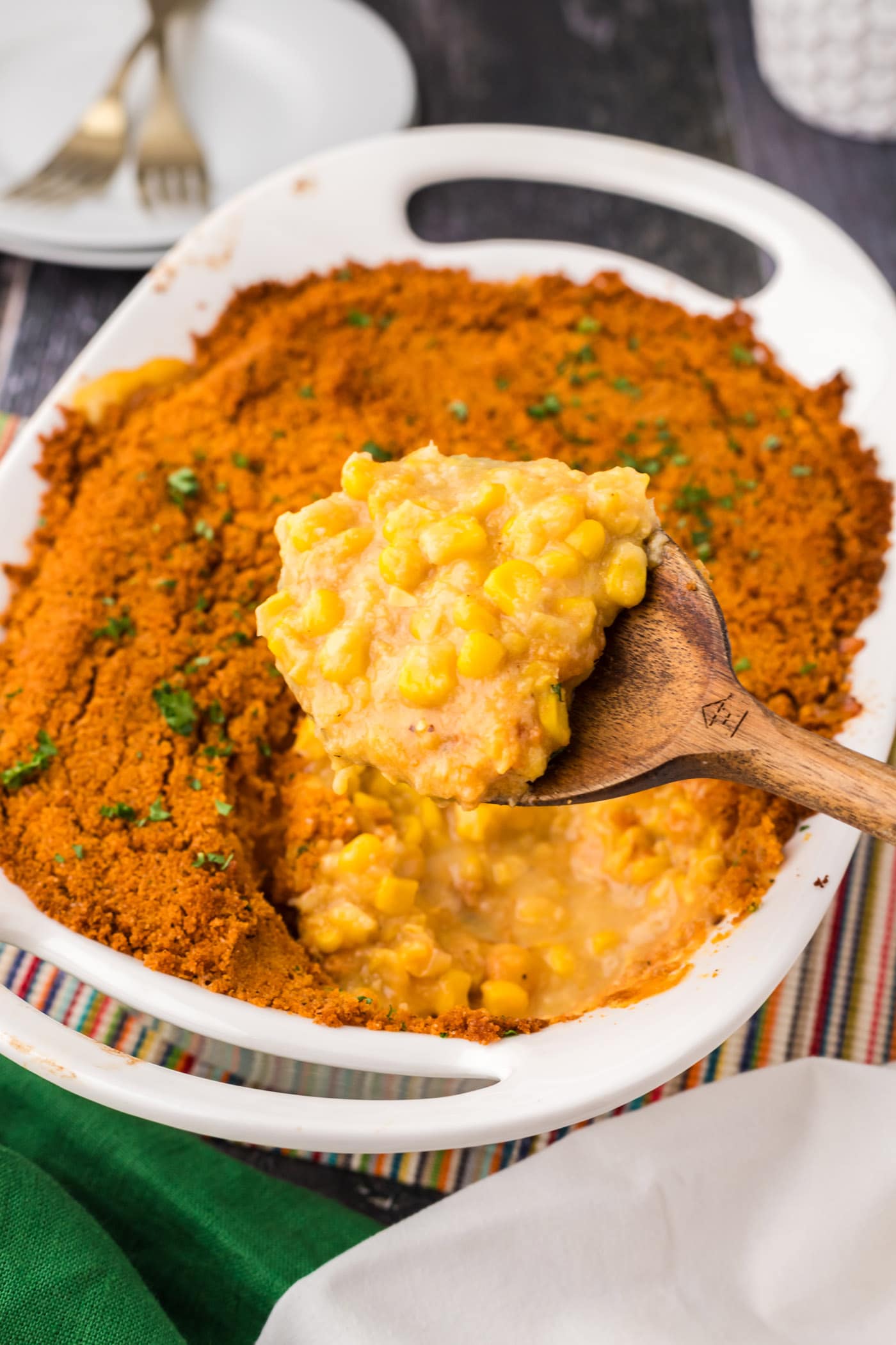 Spoonful of Scalloped Corn being lifted out of the baking dish