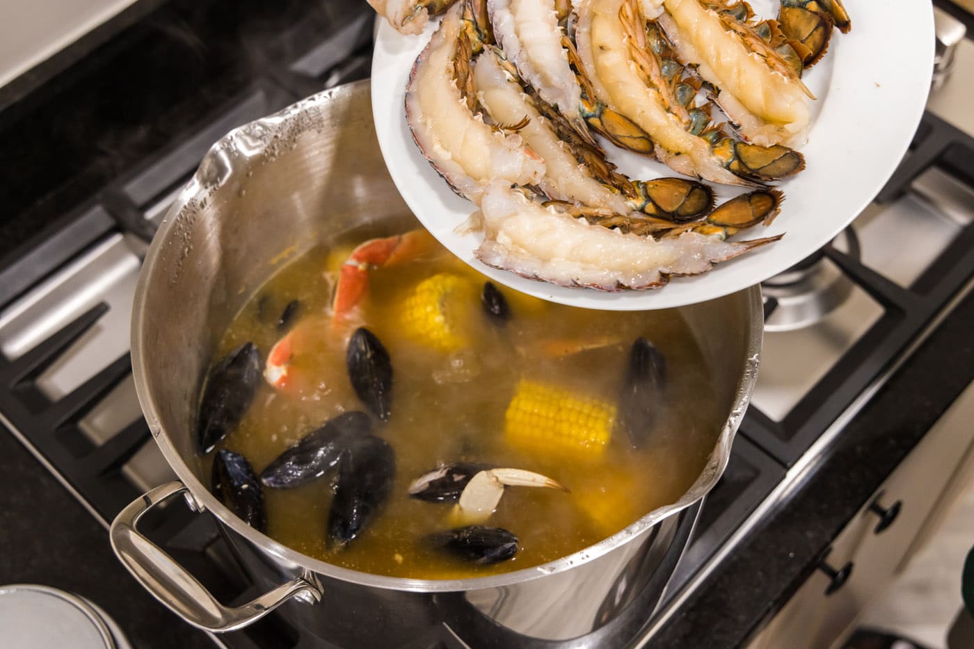 adding lobster tails to seafood boil