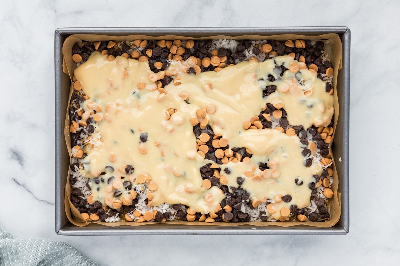 sweetened condensed milk poured over chocolate chip layer