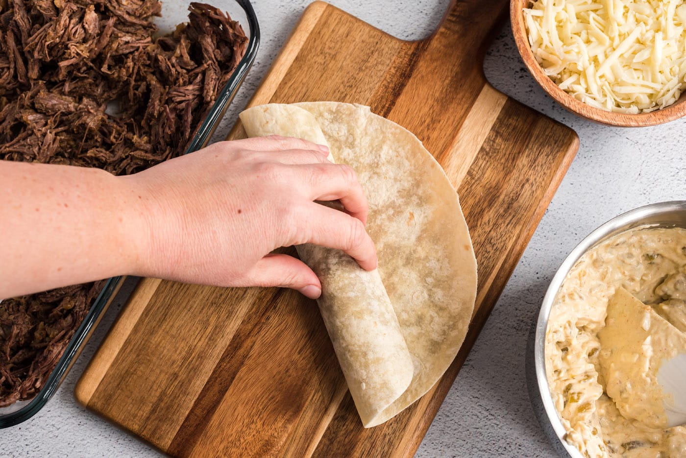 rolling up beef enchiladas