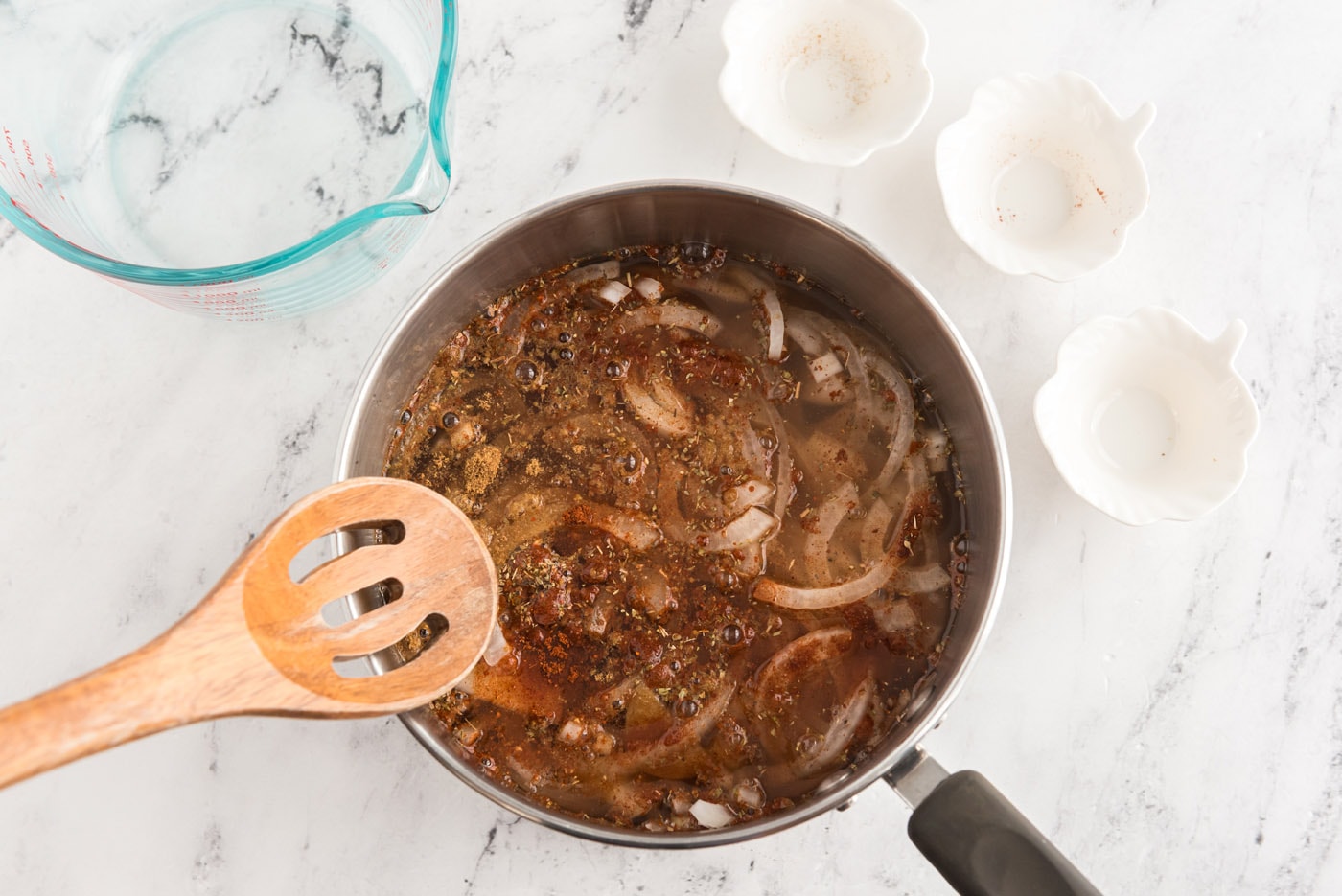 reducing onion and chicken broth mixture in a saucepan
