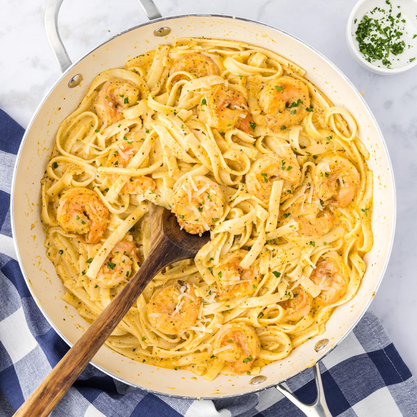 Skillet of Shrimp Alfredo with a spoon in it