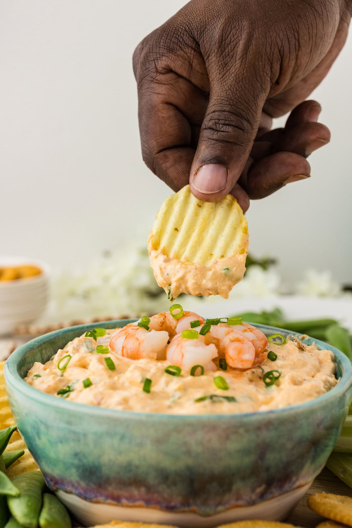 Hand holding a chip with dip on it