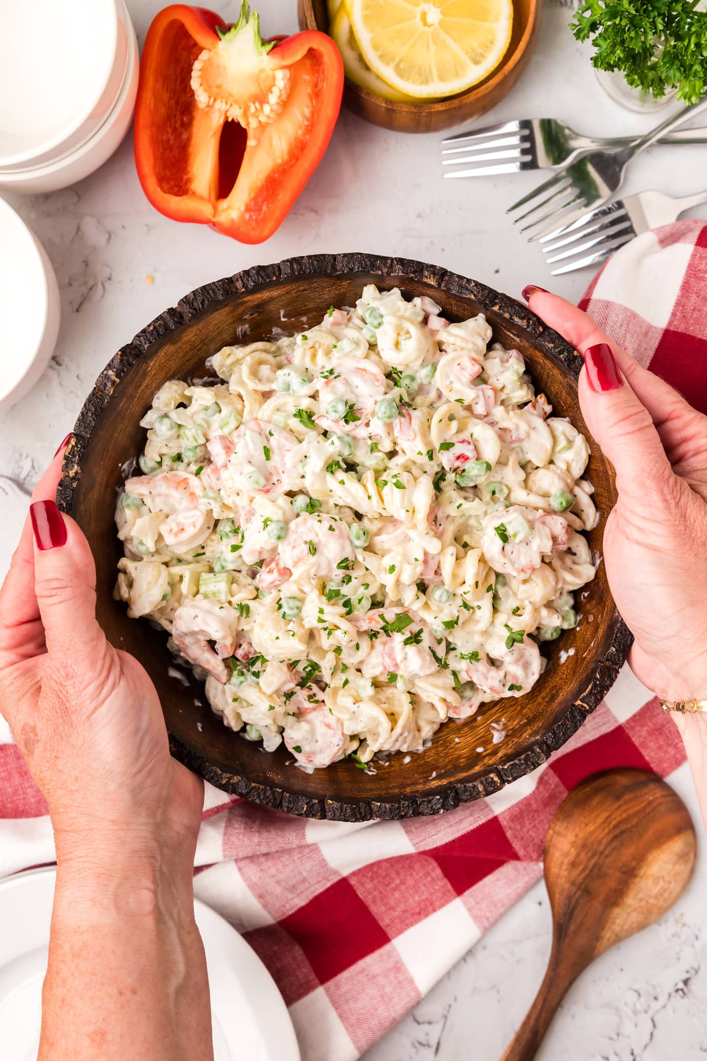Hands holding a bowl of Shrimp Pasta Salad