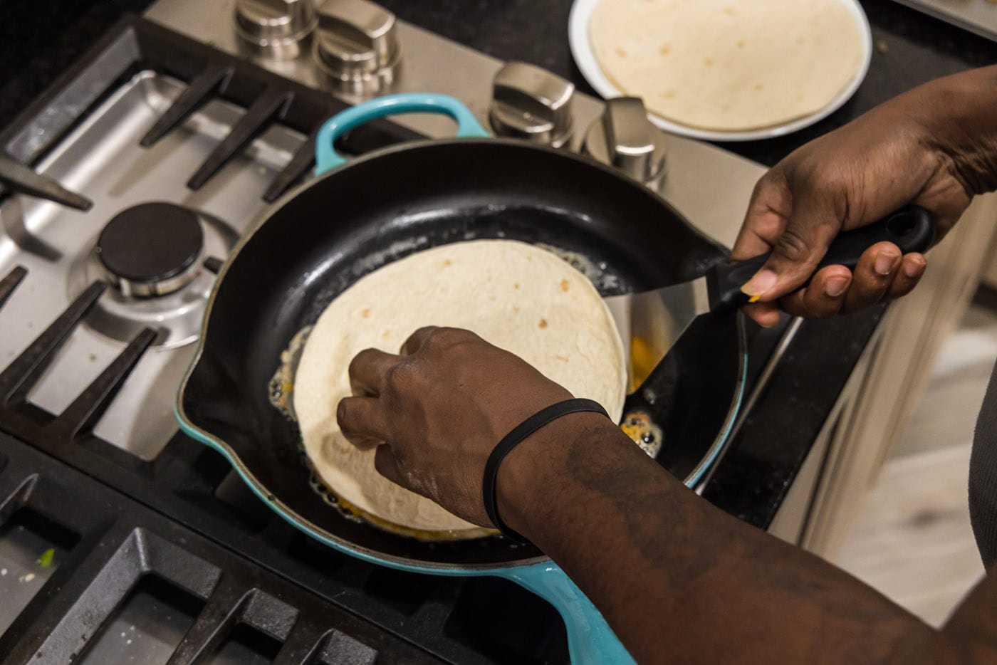 flipping shrimp quesadilla in a skillet