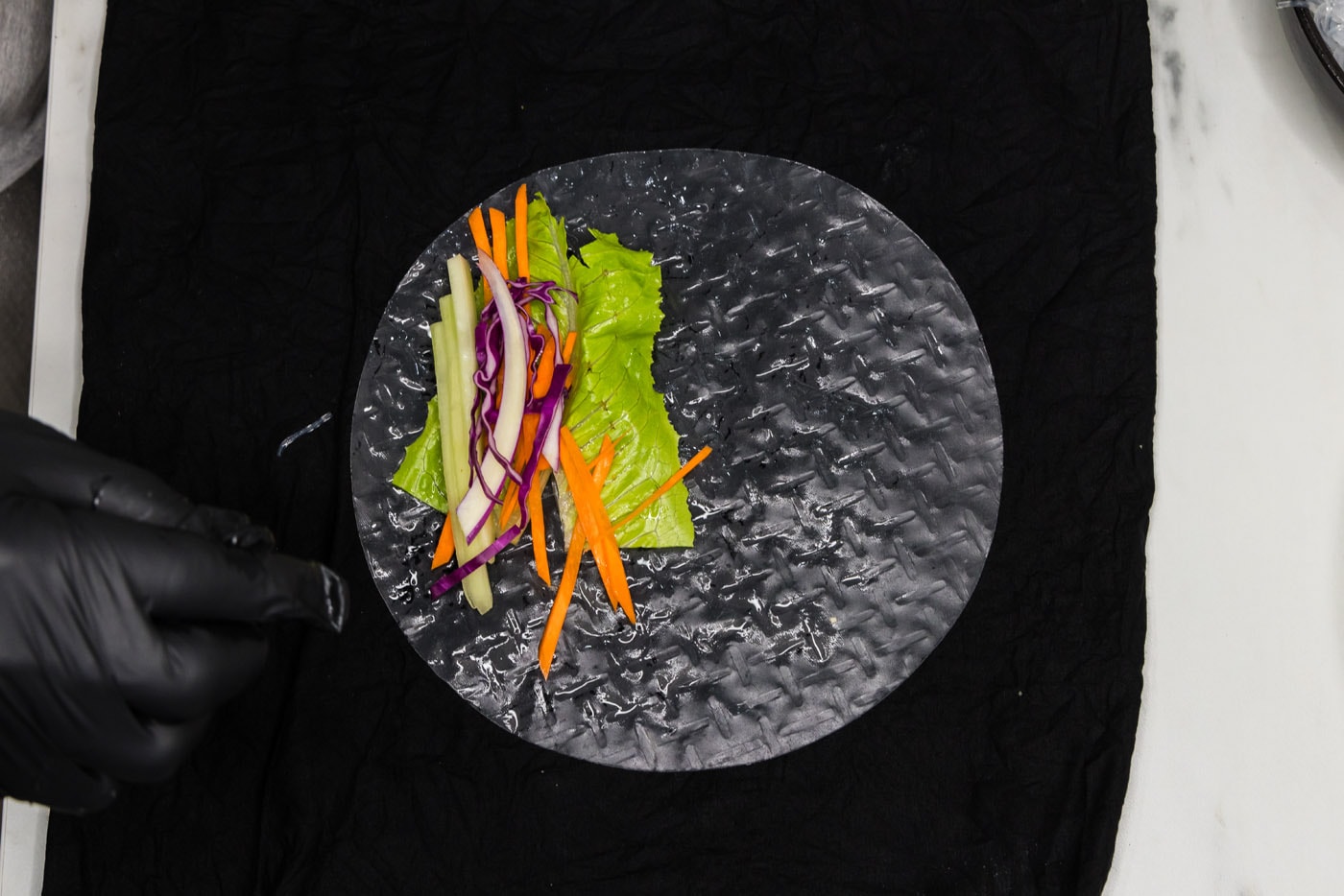 carrots, lettuce, and cabbage added to spring roll wrapper