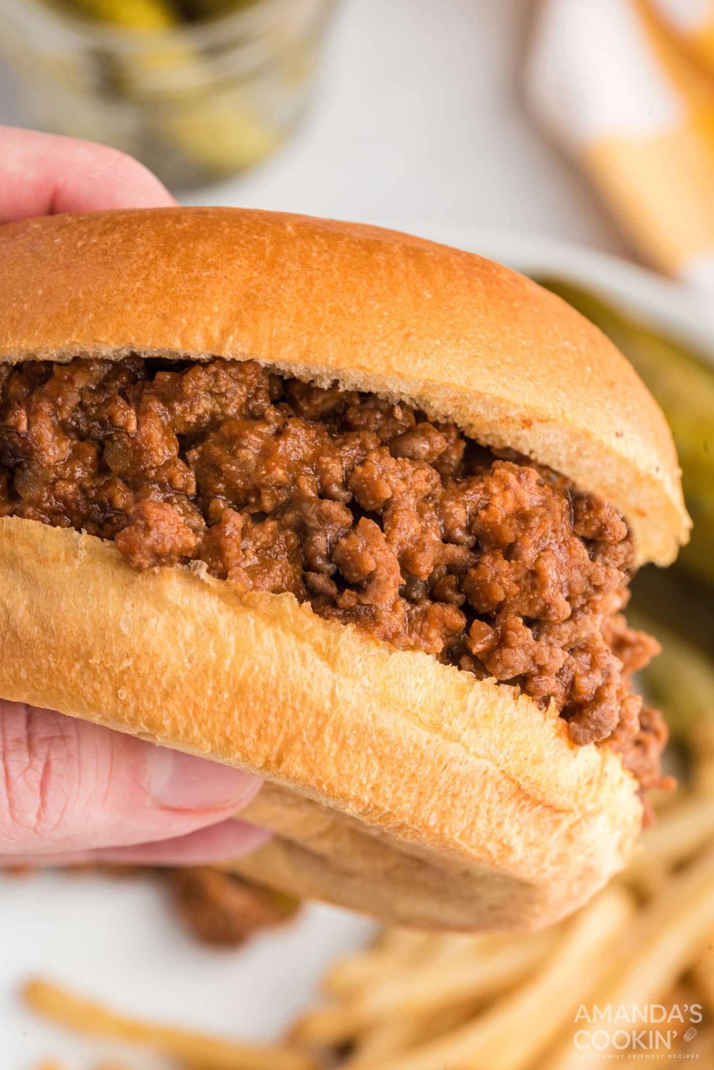 hand holding a sloppy joe sandwich