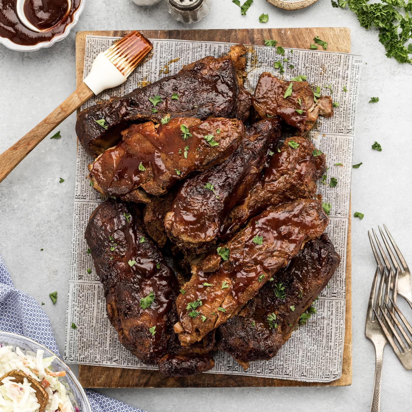 Slow Cooker Barbecued Country Style Ribs resting on a parchment lined wooden platter