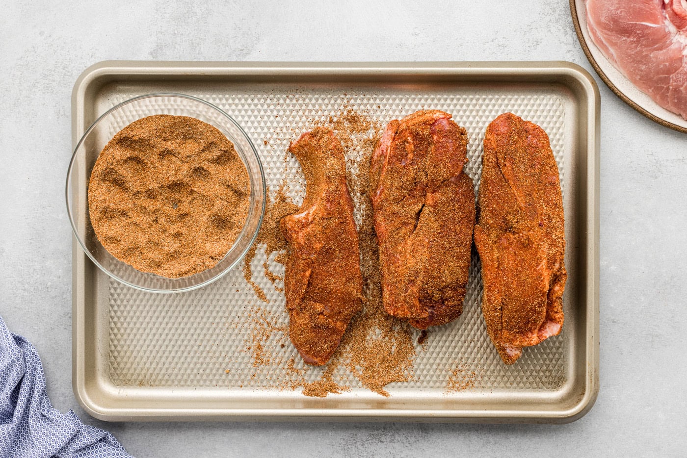 country style ribs rubbed with seasonings on a baking sheet