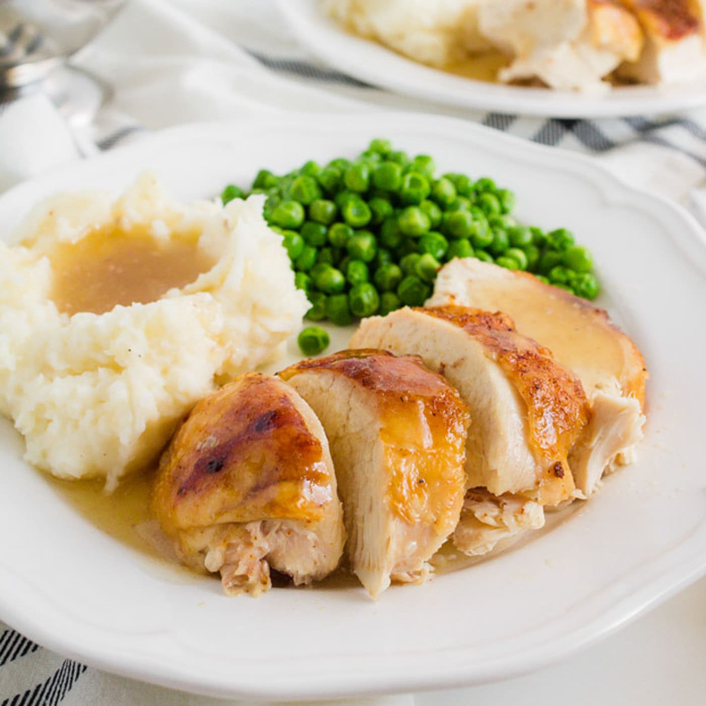 Crockpot Sticky Chicken on a plate with mashed potatoes and peas