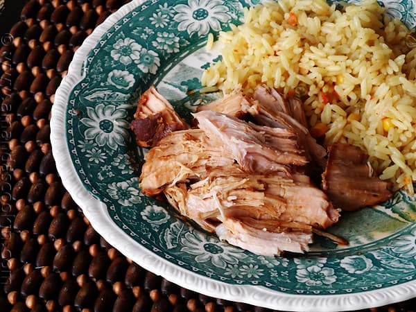 A close up photo of slow cooker oriental pork roast on a plate next to rice.