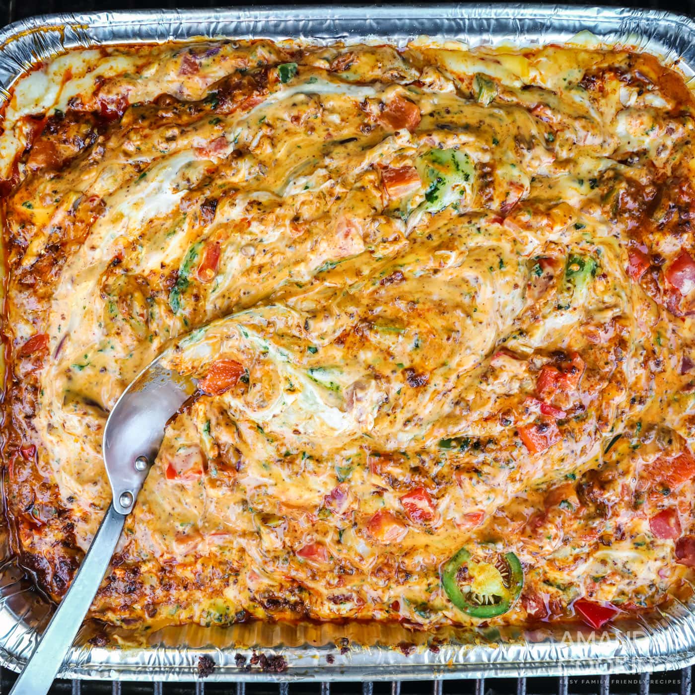 smoked queso dip in a foil pan