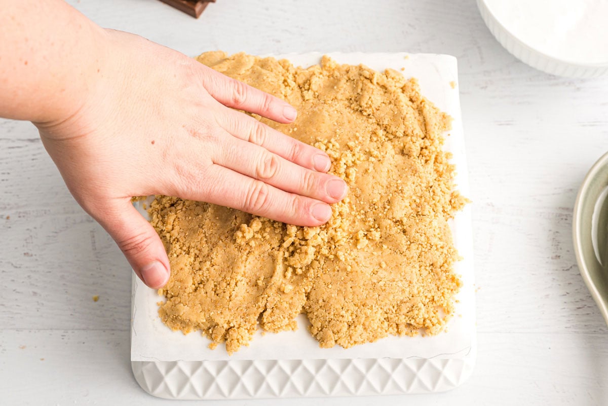 hand spreading dough on waxed paper