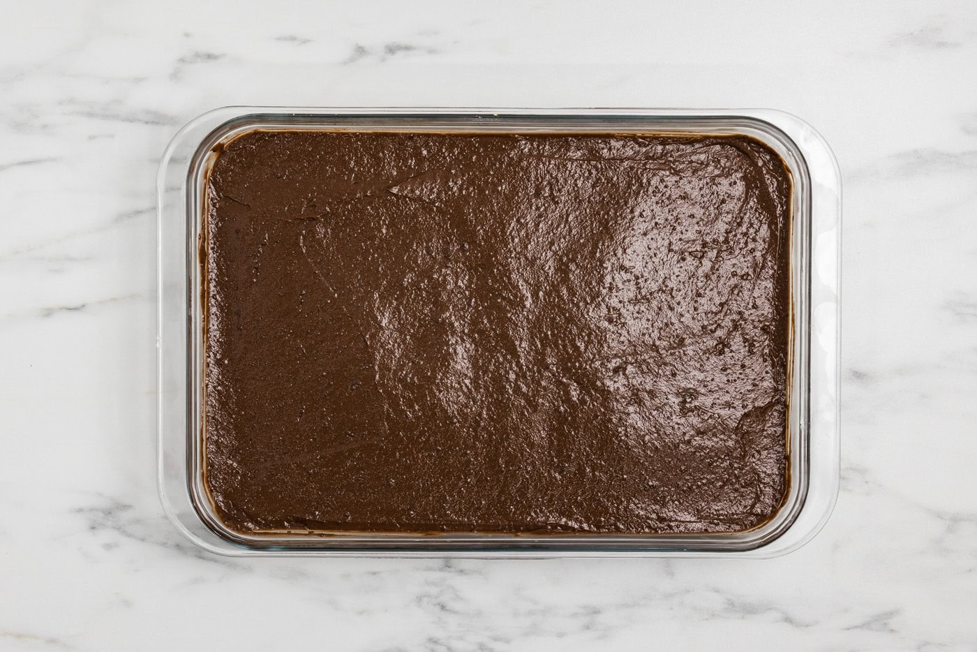 chocolate pudding layer over cheesecake and crust in a baking dish