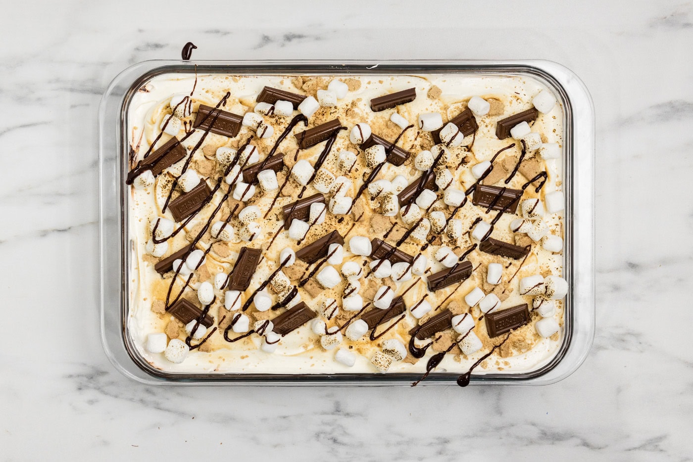 overhead shot of smores lasagna with chocolate bars and mini marshmallow garnish