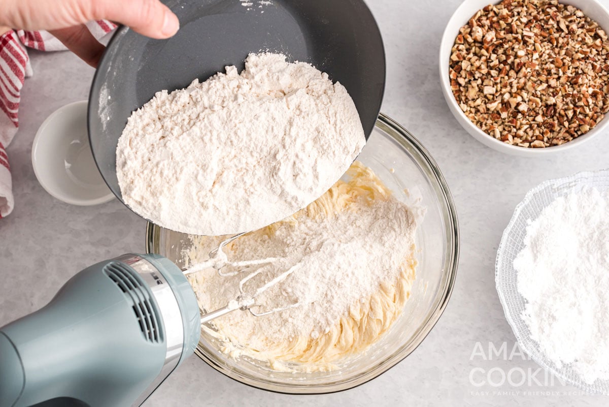 adding flour to bowl