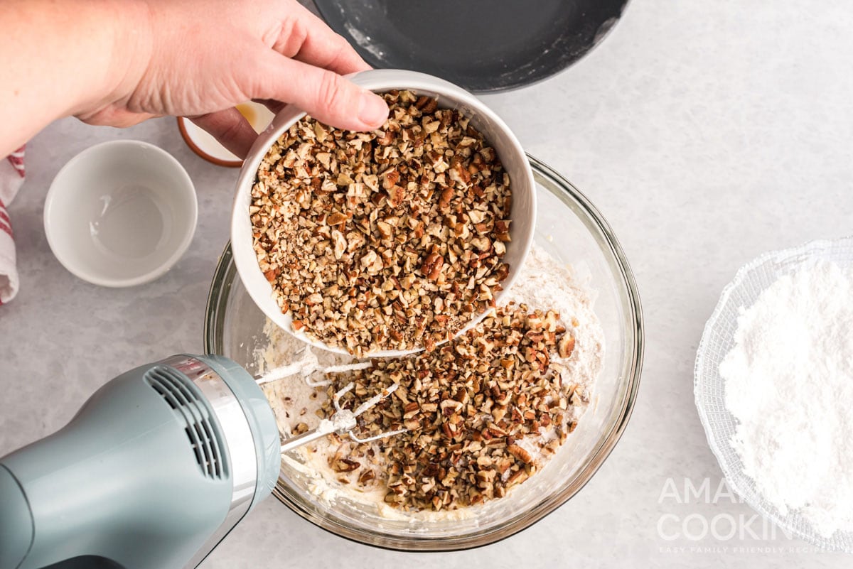 adding pecans to bowl