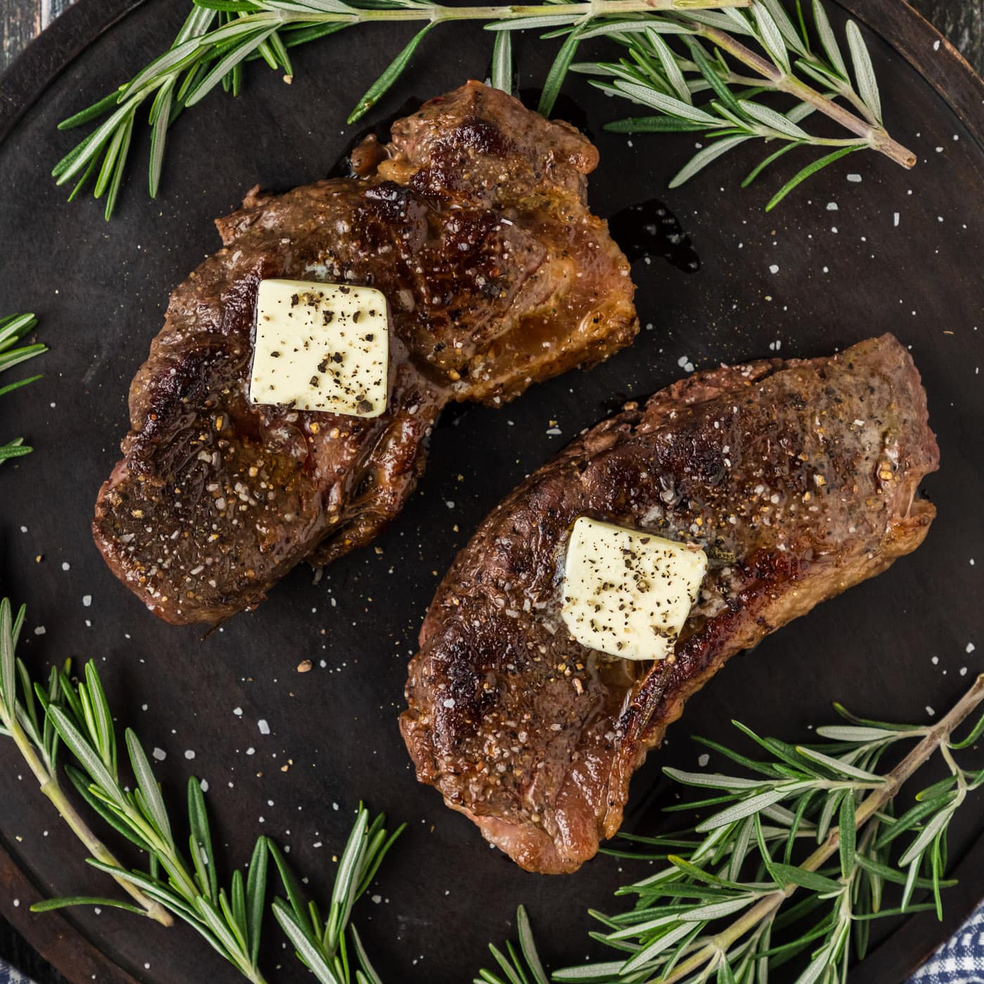 Two Sous Vide Steaks on a platter topped with butter