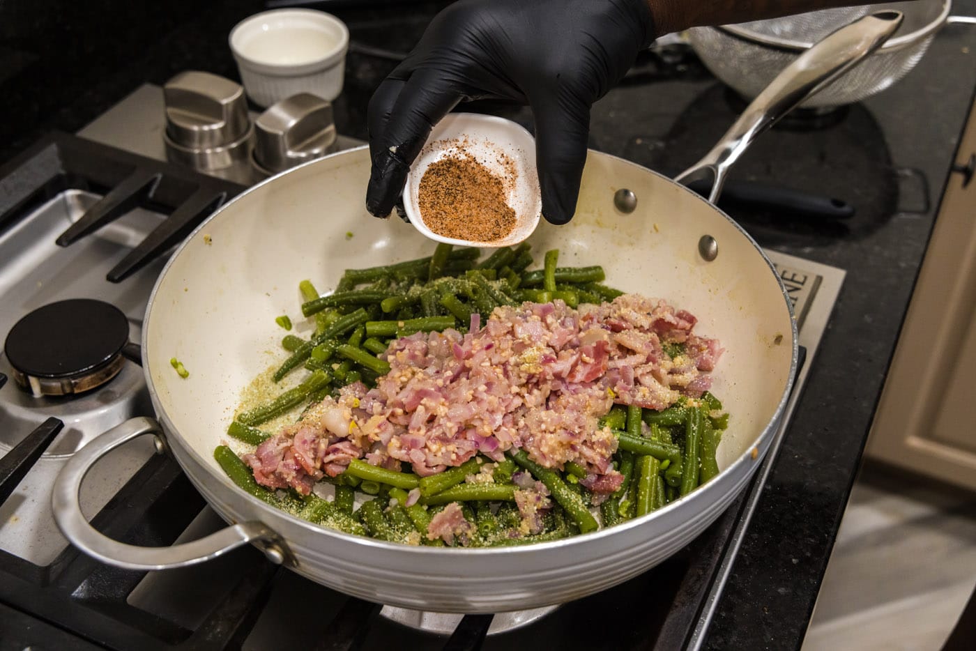 adding cajun seasoning to southern green beans