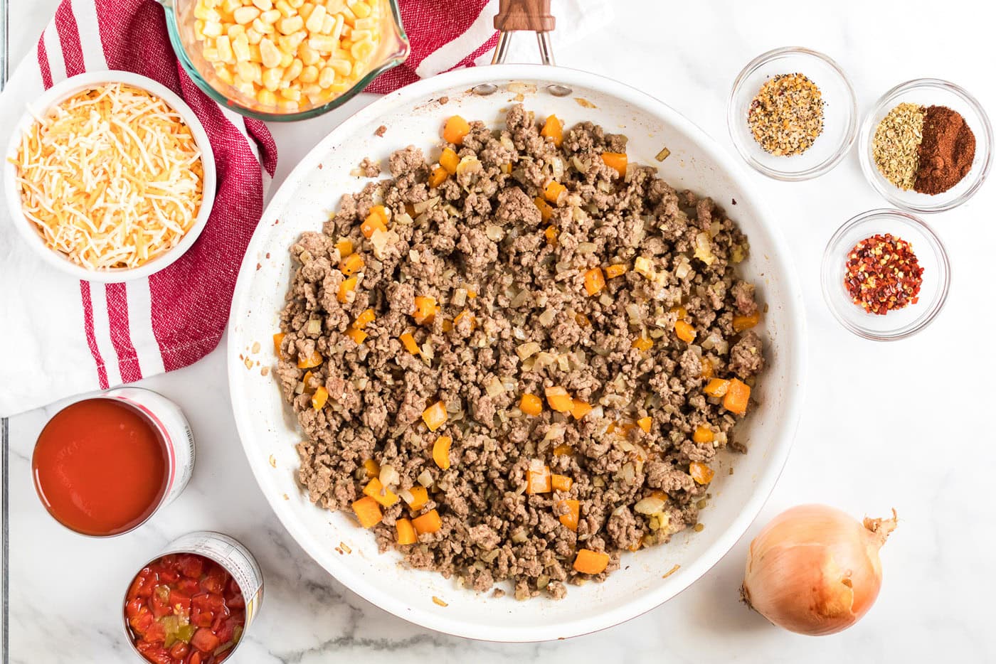 Browned ground beef and other needed ingredients to the side