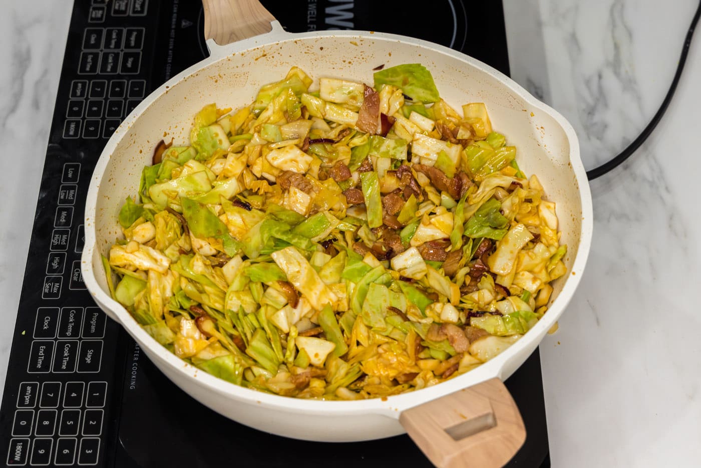 spicy fried cabbage in a skillet with seasonigs